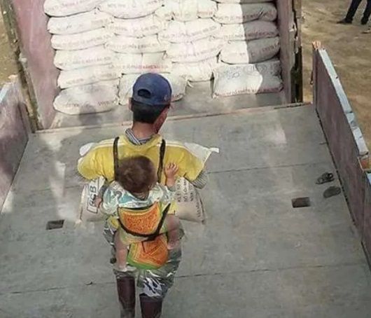 ¿Por qué el hombre carga a su hijo en la obra?
