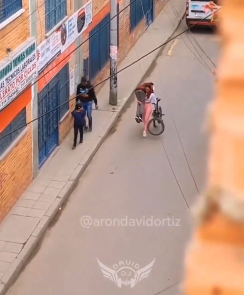 Mujer lleva a novio y bicicleta cargando 