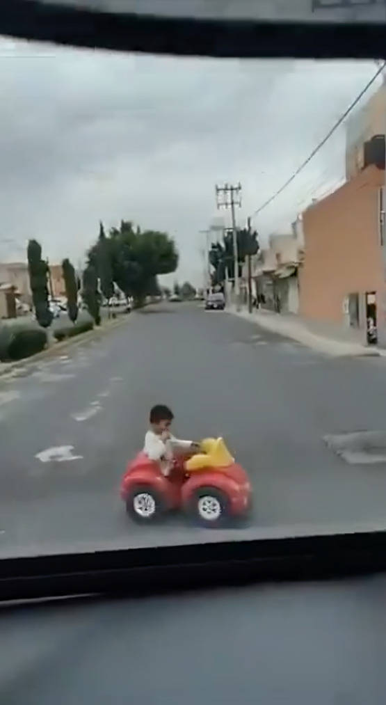 Captan a niño cruzando solo la calle con carro de juguete  