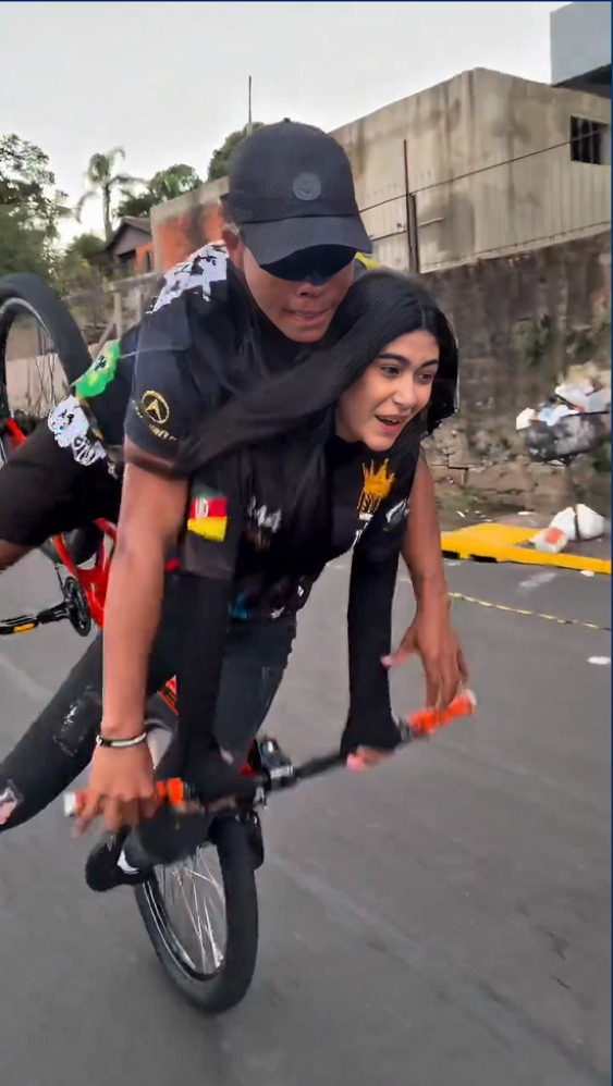 Joven hace caballito en bicicleta y tira a su novia