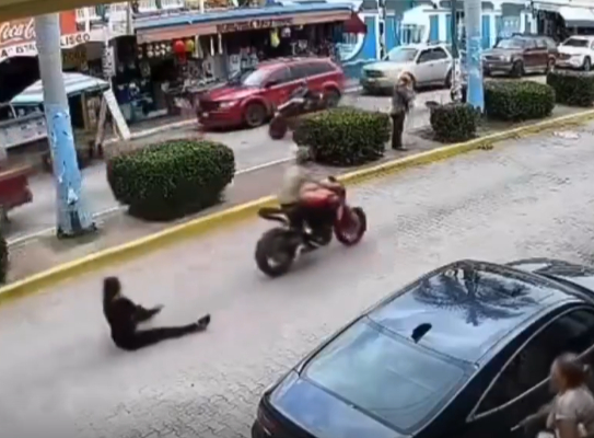 Motociclista tira a mujer en la calle